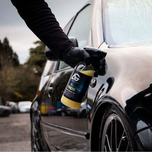 Applying Auto Glanz Prizm glass cleaner for a crystal clear and smear-free finish.